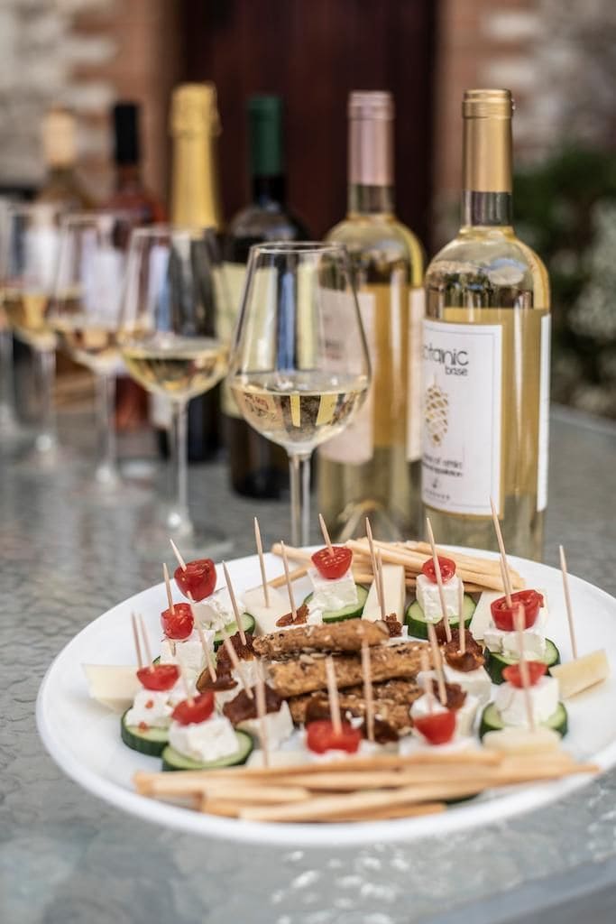 plate with aperitives and wine bottles and glasses